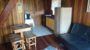 a small kitchen with a couch and a refrigerator at Pousada Recanto Varanda do Sol in Joanópolis