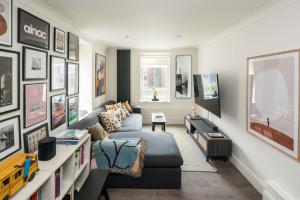 a living room with a couch and a tv at Ideal 1BD Flat Shoreditch For City Explorers in London