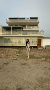 a person riding a horse in front of a building at YOLO House Beach in Asia