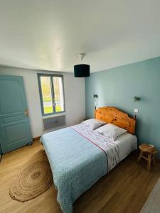 1 dormitorio con 1 cama grande y cabecero de madera en Gîte Entre Terre et Marais, en Noyelles-sur-Mer