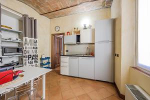 cocina con armarios blancos y nevera blanca en Modena Palace Suite [Duomo - 5 Stelle], en Módena