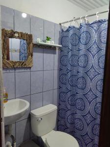 a bathroom with a toilet and a shower curtain at Casa Victoria in Puntarenas