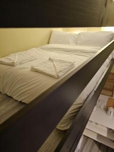 a bed with white sheets and two towels on it at Boutique Studio in King's Cross in London