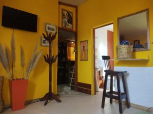 sala de estar con pared amarilla y TV en El REFUGIO DE KARIM en San Rafael