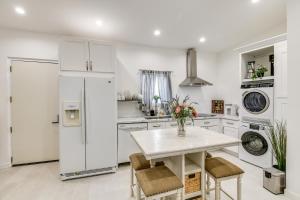 a kitchen with white appliances and a table and chairs at East Los Angeles Studio - Near Dodger Stadium! in East Los Angeles