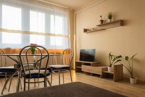 a living room with a table and chairs and a television at BB Panorama apartman in Budapest