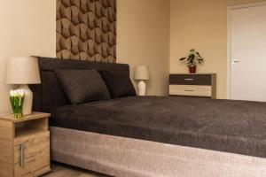 a bedroom with a large bed and a table with a plant at BB Panorama apartman in Budapest