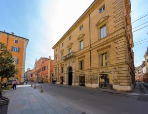 un gran edificio de ladrillo en el lateral de una calle en Modena Palace Suite [Duomo - 5 Stelle], en Módena