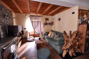 a living room with a couch and a tv at Appartamento Collomb Ruitor in La Thuile