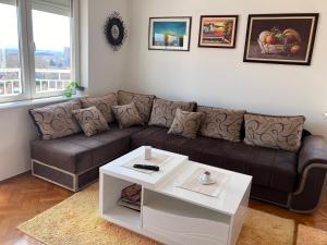 uma sala de estar com um sofá castanho e uma mesa em Apartman PRESSTIGE em Smederevska Palanka