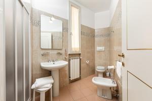 bagno con lavandino, servizi igienici e specchio di Hotel Minerva a Siena