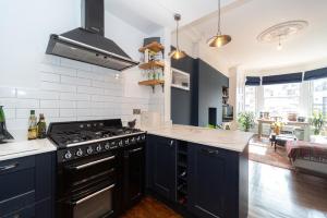 cocina con armarios azules y fogones en Montgomery Large 2 Bedroom Flat - 5 Mins Walk to City Centre, en Edimburgo