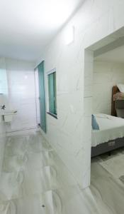 Habitación blanca con cama y baño. en Home Superior Nascer do Sol en Cairu