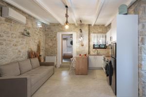a living room with a couch and a kitchen at Treasure of Herbs Complex in Panormos Rethymno