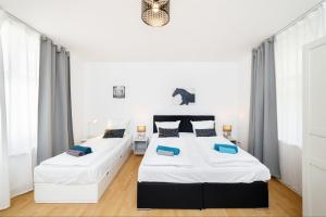 two beds in a bedroom with white walls at Great Central City Apartments Mitte Museumsinsel in Berlin