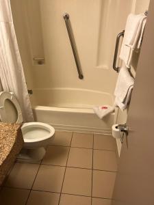 a bathroom with a toilet and a bath tub at Red Carpet Inn Quantico in Dumfries