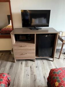 a wooden entertainment center with a flat screen tv on it at Red Carpet Inn Quantico in Dumfries