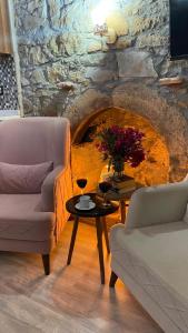 sala de estar con sofá y mesa con copas de vino en Kalyopi Köy Evi, en Gokceada Town