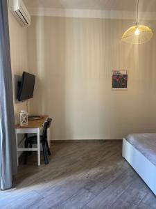 a room with a desk with a computer and a bed at Elena Rooms in Taranto
