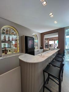 a bar in a restaurant with a counter and chairs at Nayru Hotel in Toledo