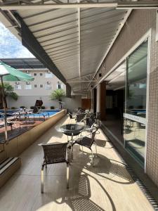 un patio con mesa, sillas y piscina en Nayru Hotel, en Toledo