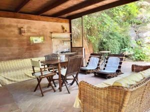 patio con mesa y sillas y cocina en Lo Chalet d'Argento, en Porto Ercole
