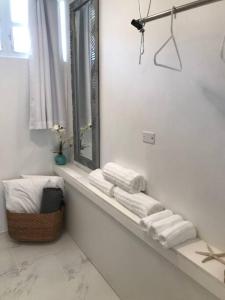 a white bathroom with towels on a window ledge at Ocean View 1 Bedroom Cabana in Condado! in San Juan