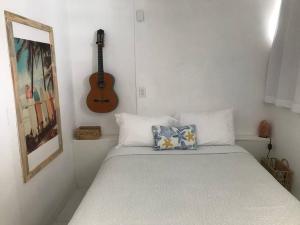 a bedroom with a bed with a guitar on the wall at Ocean View 1 Bedroom Cabana in Condado! in San Juan +21 photos