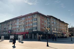 a large building with people walking in front of it at Luxury Apartament Ultracentral of Suceava Esplanada in Suceava