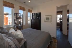 a bedroom with a bed and a dresser and windows at Charming Savannah Penthouse: Grand Views & Dual Parking in Savannah