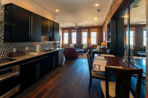 a kitchen with black cabinets and a dining table at Charming Savannah Penthouse: Grand Views & Dual Parking in Savannah