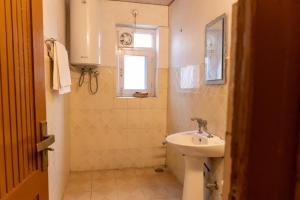 baño con lavabo y aseo y ventana en Bali guest house, en Srinagar