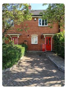 a red brick house with a red door at Quaint and Serene Single room in London