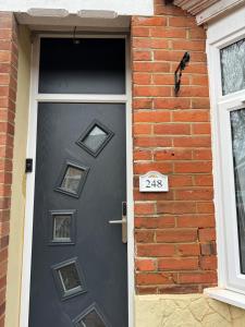 uma porta de uma casa de tijolos com um sinal em High street home em Eastleigh