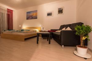 a living room with a couch and a bed at Flataid Apartment Elisabethinergasse in Graz