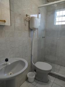 a bathroom with a sink and a toilet and a shower at Pousada Golfinhos in Imbé