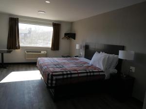 um quarto de hotel com uma cama e uma janela em Hilltop Express Inn em Groton