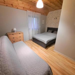 a bedroom with two beds and a dresser in it at Domki Letniskowe Cztery Pory Roku in Skorzęcin