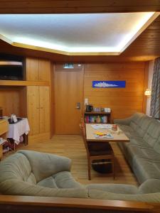 a living room with a couch and a table at Hotel Garni Alpenruh in Lenk