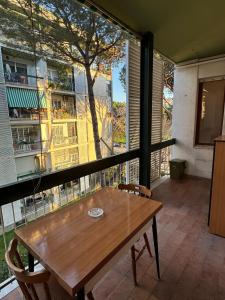 Umanesimo Resort Apartment في روما: طاولة وكراسي على شرفة مع نافذة كبيرة