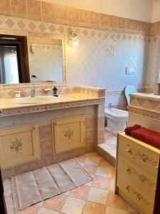 a bathroom with a sink and a toilet and a mirror at A casa di Ale in Frascati