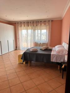 a bedroom with a bed and a large window at A casa di Ale in Frascati