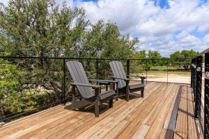 duas cadeiras sentadas no convés de uma casa em New Oak Grove-Container Retreat em Fredericksburg