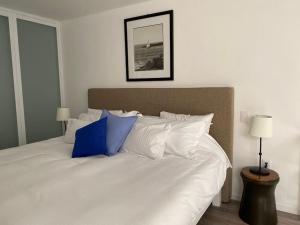 a bedroom with a white bed with blue pillows at Increíble Loft en Centro Histórico de Guadalajara in Guadalajara +61 photos