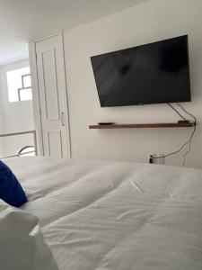 a bedroom with a bed with a flat screen tv on the wall at Increíble Loft en Centro Histórico de Guadalajara in Guadalajara