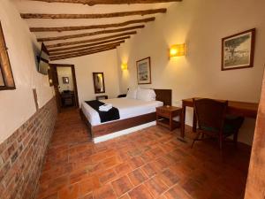 a bedroom with a bed and a table in a room at EcoHotel Barichara in Barichara