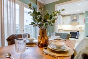 uma mesa de madeira com um vaso com flores em Quaint 3 bedroom Cottage with Private Parking by Eagle Owl Property em Worthing