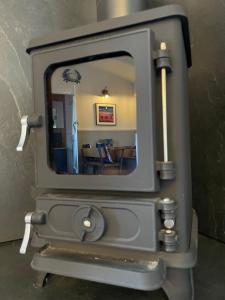 a mirror in a wood stove with a dining room at The Grove Glamping in Cromer