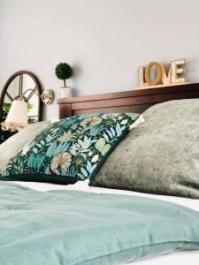 a bedroom with a bed with a green pillow and a clock at Casa da Lomba Piscina y vistas al mar en Baiona in Baiona