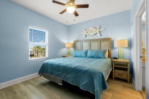 a blue bedroom with a bed and a ceiling fan at Lovely Resort Low Floor Condo! Just Steps to the Beach & Restaurants! by Dolce Vita Getaways PCB in Panama City Beach